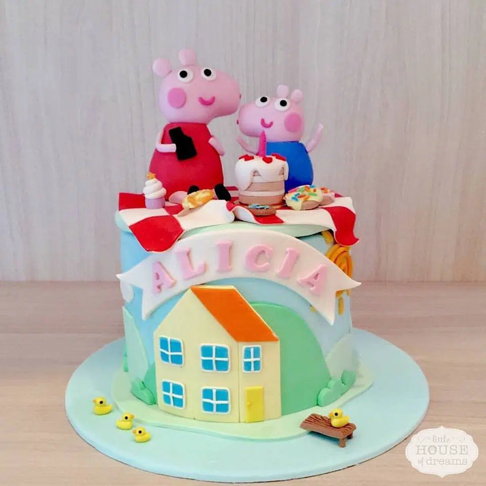 A round cake decorated with edible Peppa and George figurines. Little House of Dreams.Source