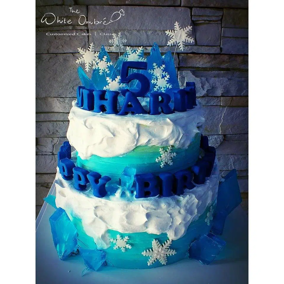 A two-tiered round cake gorgeously decorated with edible sugar rocks, snowflakes and for a Frozen themed cake. The White Ombre.Source