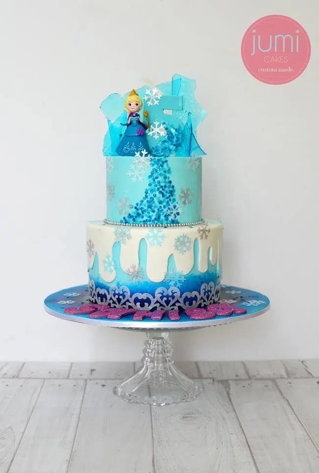 A two-tiered Frozen themed cake that was decorated with edible paint, fondant and sugar glass detailings. Jumi Cakes.Source