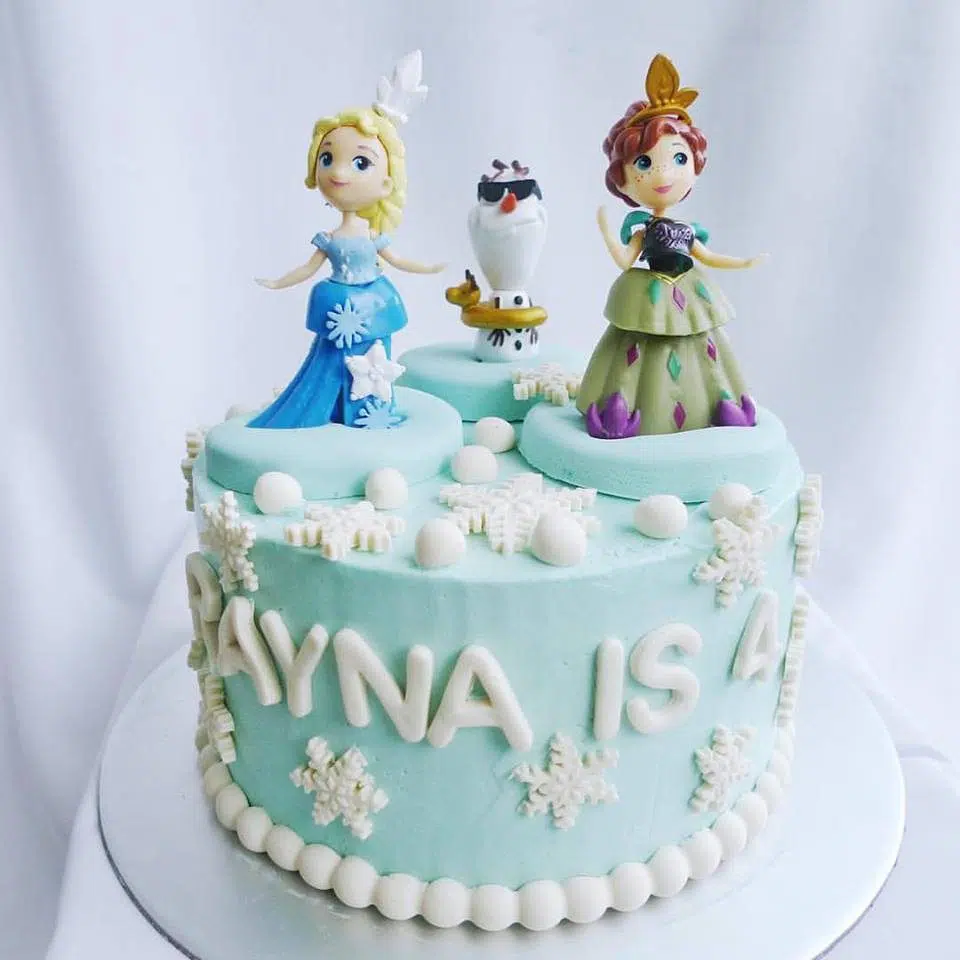 A Frozen themed cake decorated with figurines of Elsa, Anna and Olaf. Corine and Cake. Source