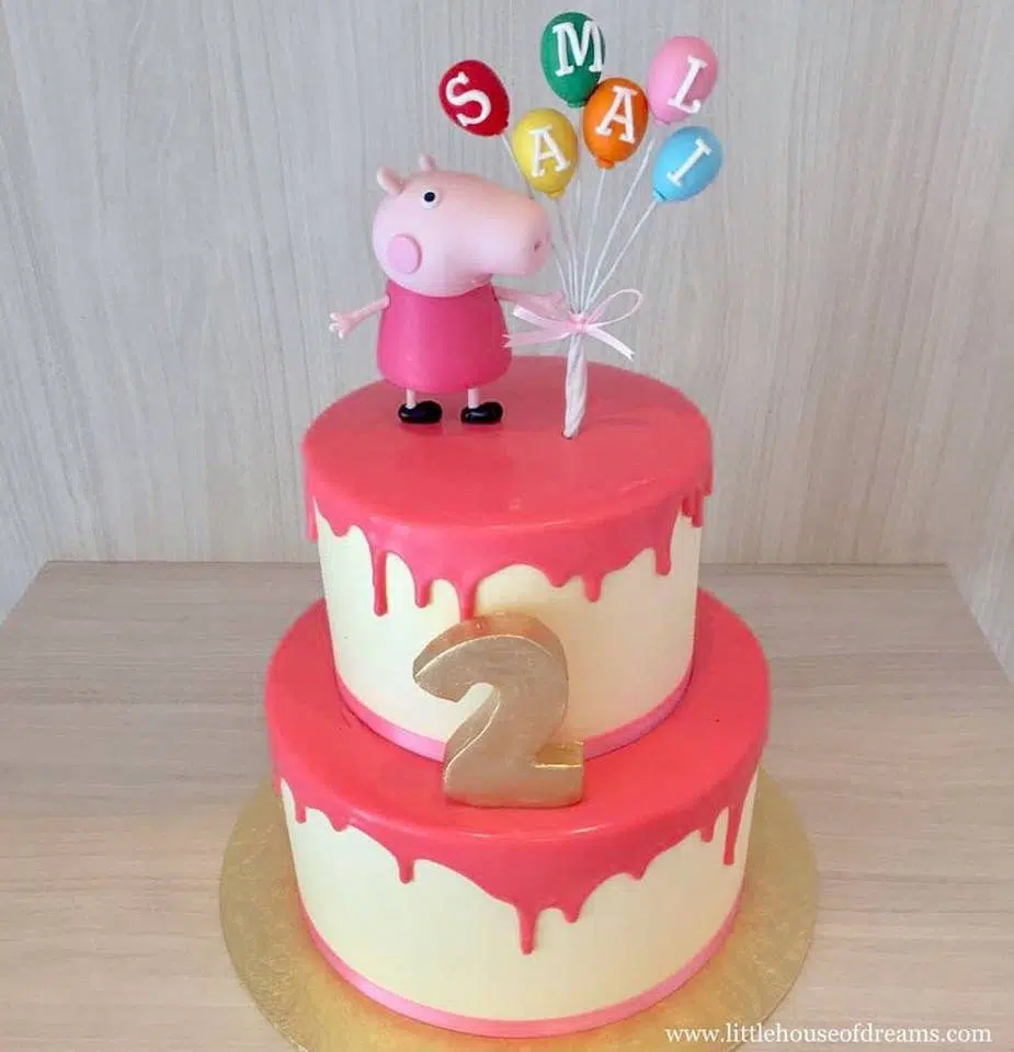 A two-tiered cake with dripping frosting effect and Peppa Pig figurine cake topper. Little House of Dreams.Source