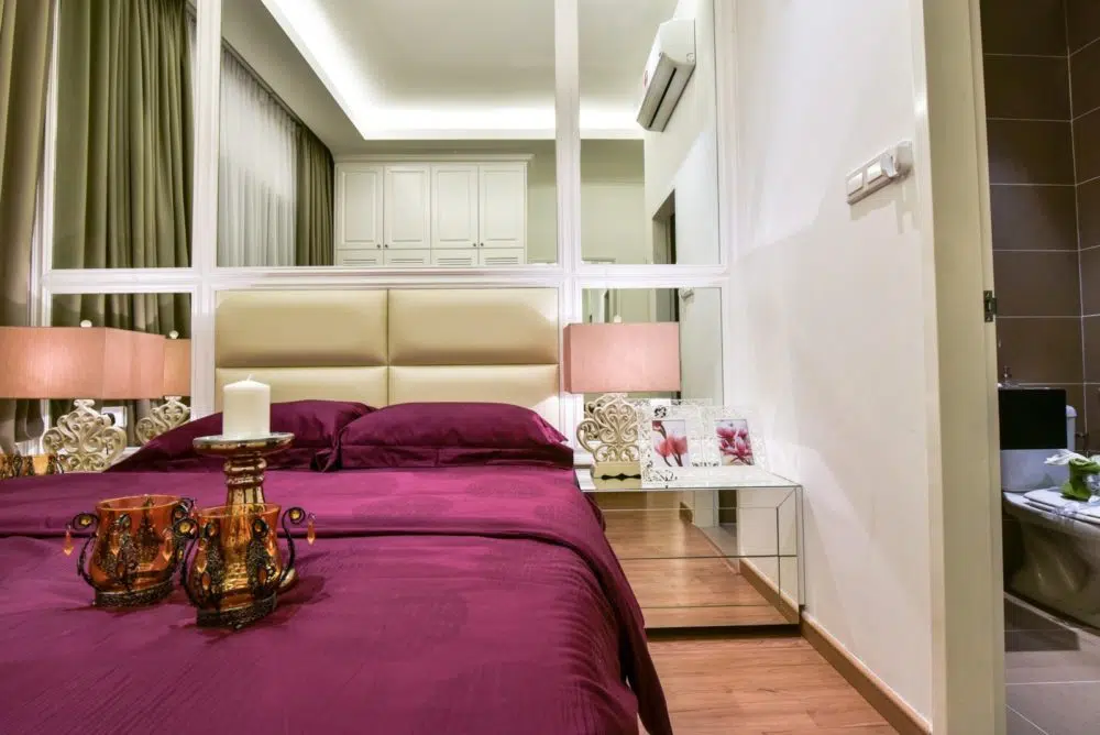 In this bedroom project in Ceria Residence, Cyberjaya by Nice Style Interior Design, wall-to-wall mirror panels added to practically double the bedroom depth. There's even matching mirrored bedside tables to stretch the floor space even further.
