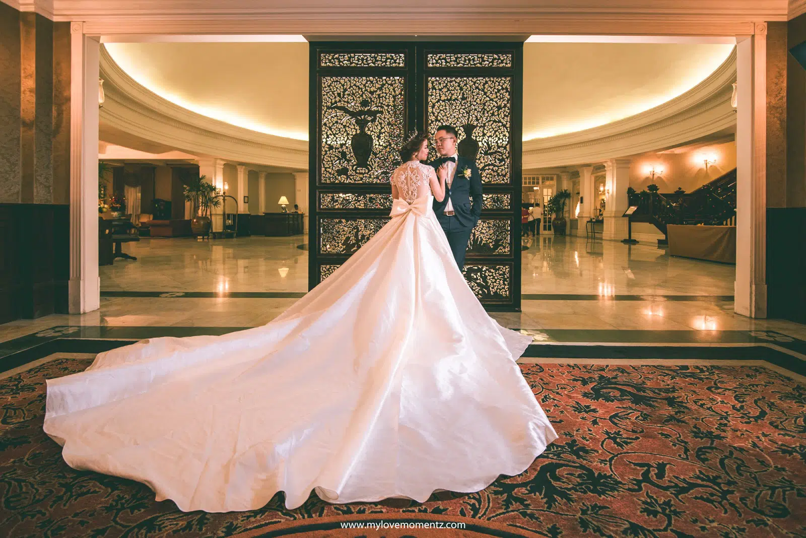 Bride and groom posing outside the ballroom of the E&amp;O Hotel in Penang, Malaysia. Photo by My Love Momentz