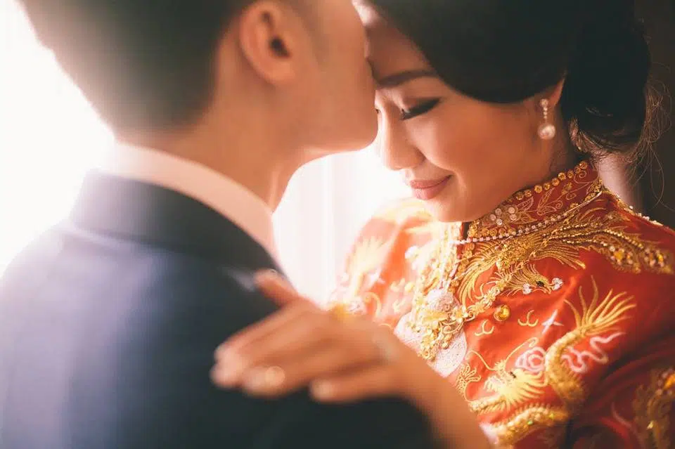 Groom kisses bride on the forehead before Malaysian Chinese wedding tea ceremony. Photo by Shuttering Hearts