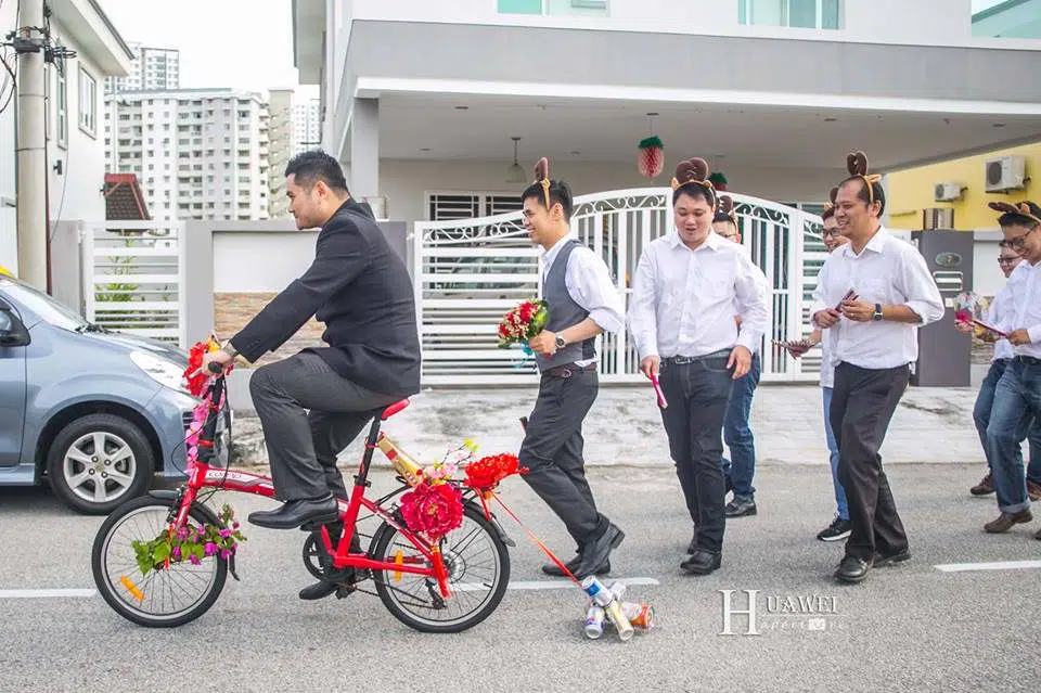 Malaysian Chinese Groom riding bicycle to gatecrashing with hengtai. Photo by Hua Wei Aperture. Get quotes for prewedding photography at Recommend.my