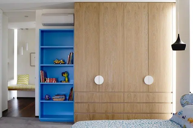 Natural timber kids cupboard with bright blue display shelves