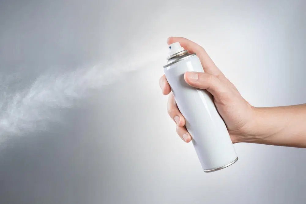 Spraying disinfectant aerosol spray into the air