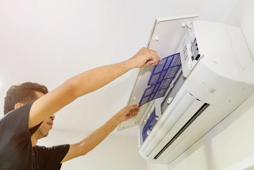 Clogged aircon filter being removed for cleaning