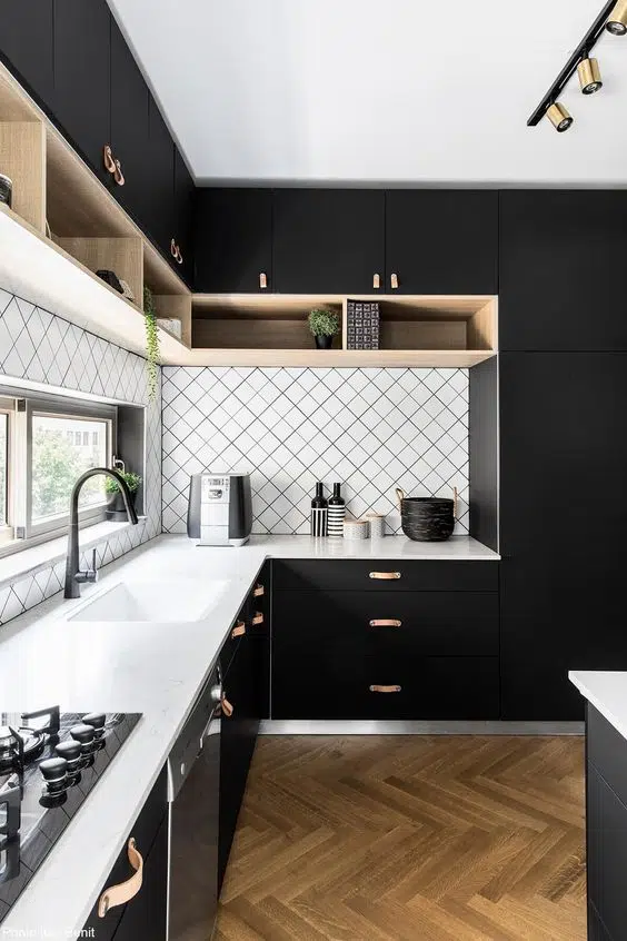 Black kitchen cabinetry with leather door handles and light toned accents 