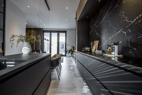 Modern black dry kitchen with a large black marble backsplash