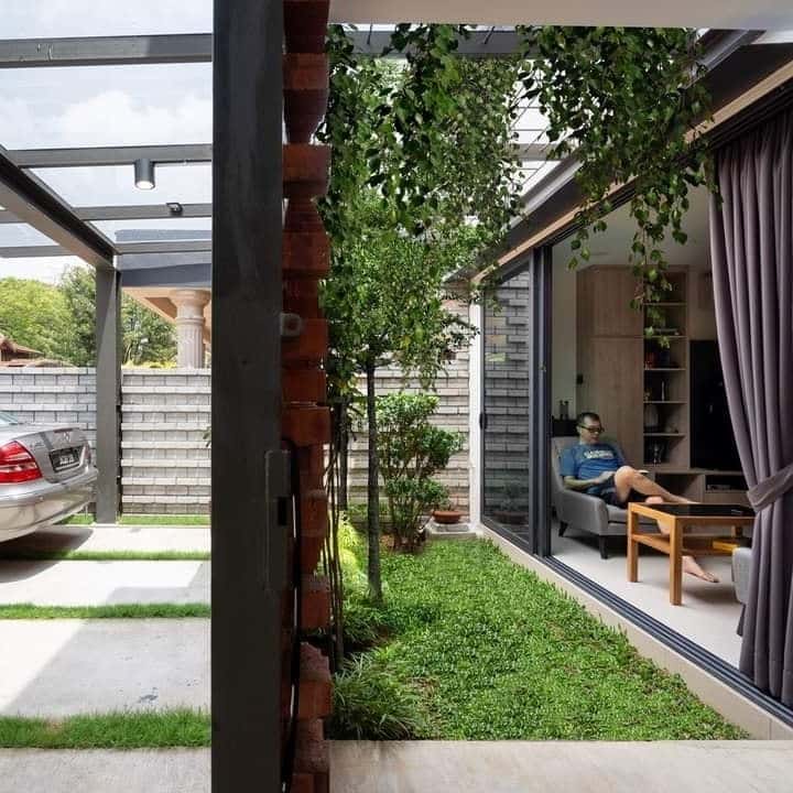 Brick wall divider in the driveway doubles as a green wall in this KL home. Design by O2 Atelier